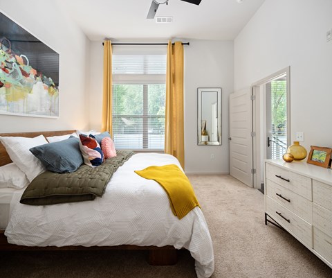 a bedroom with a bed and a dresser and a window
