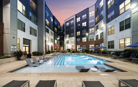 a swimming pool in front of an apartment building with a pool