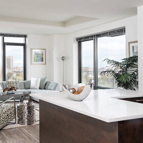 A modern kitchen with a large island and a view of the city.