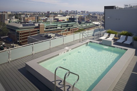 A rooftop pool with a cityscape in the background.
