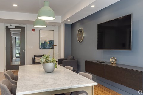 A modern dining room with a marble table and grey chairs.