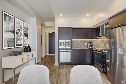A modern kitchen with a stainless steel refrigerator and wooden cabinets.