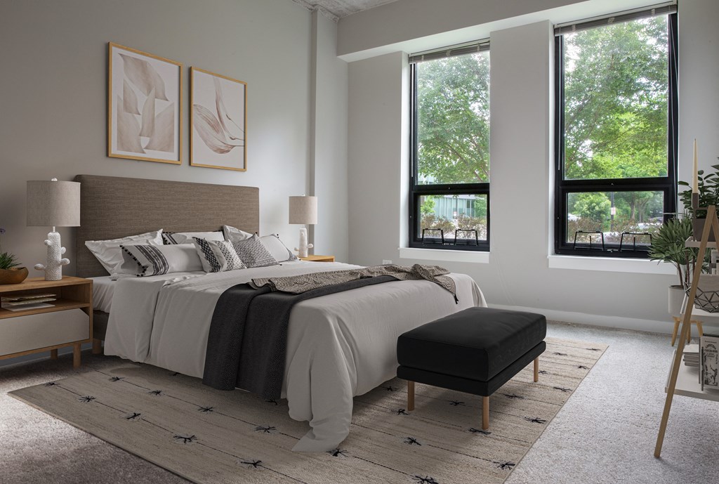 a bedroom with a bed and two windows