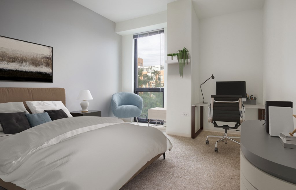 a bedroom with a bed and a desk with a computer