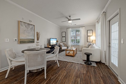 A living room with a painting on the wall and a fan on the ceiling.