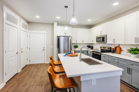 a large kitchen with a white counter top and stainless steel appliances