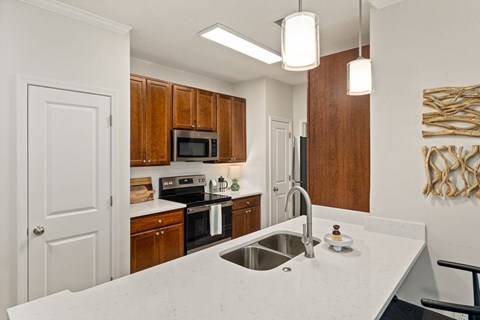 A kitchen with a white counter top and wooden cabinets.
