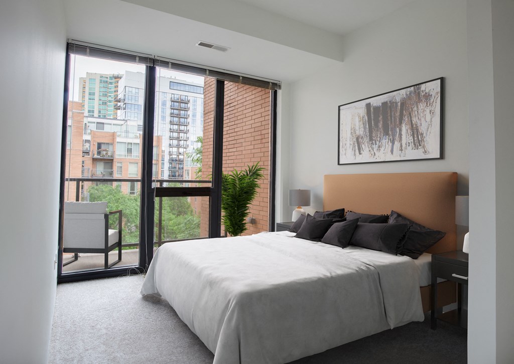 a bedroom with a bed and a sliding glass door to a balcony