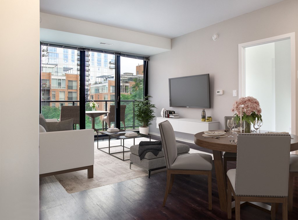 a living room and dining room with a table and chairs and a television