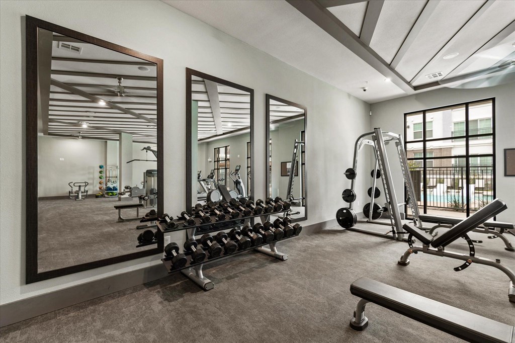 a home gym with weights and mirrors