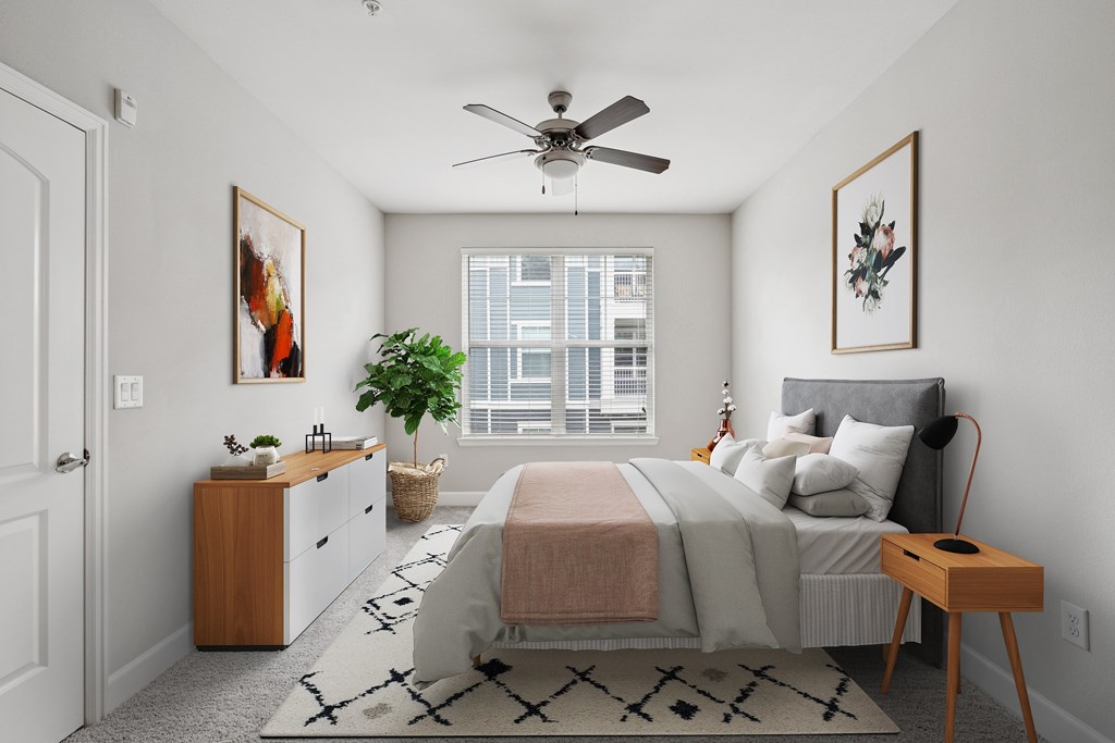 A bedroom with a bed, nightstand, and a ceiling fan.