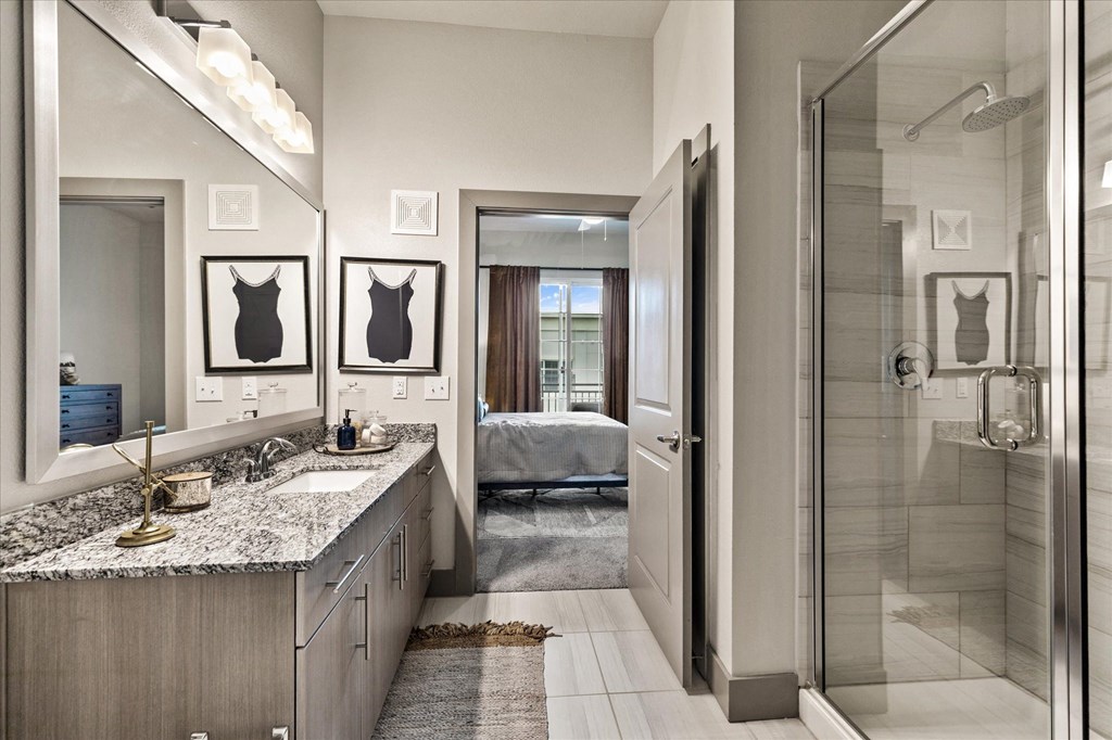 a bathroom with a walk in shower and a double sink