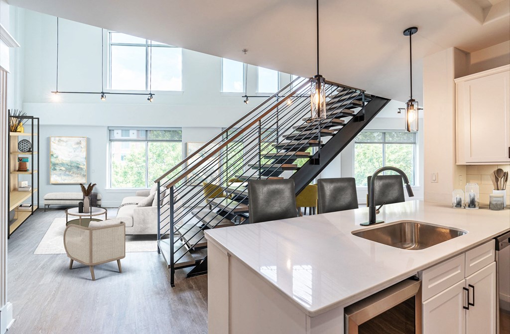 a kitchen with a sink and a staircase in a house