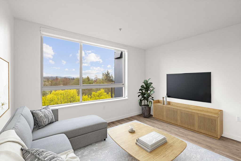 a living room with a large window with a view of a yellow rapeseed field