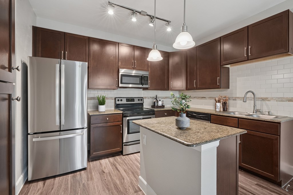 A kitchen with brown cabinets and a white island.