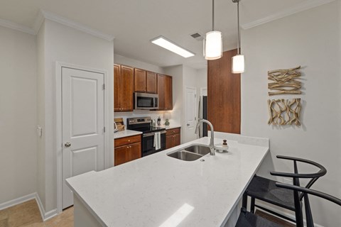 A kitchen with a white counter top and wooden cabinets.