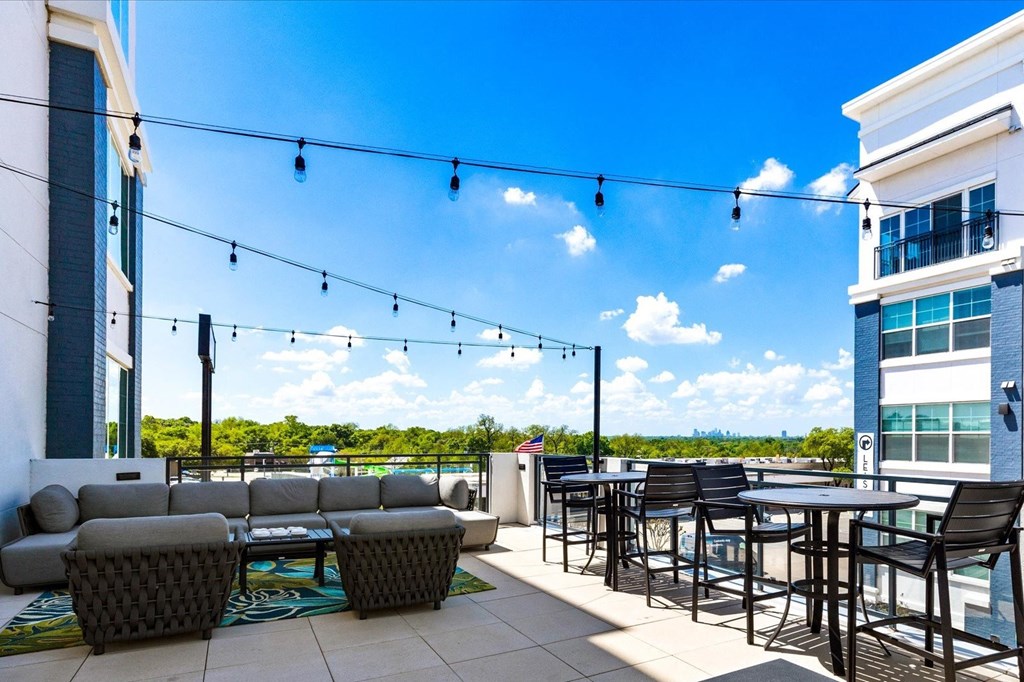 a patio with tables and chairs and a view of the water