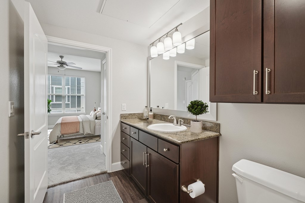 A bathroom with a brown vanity and a white bathtub.