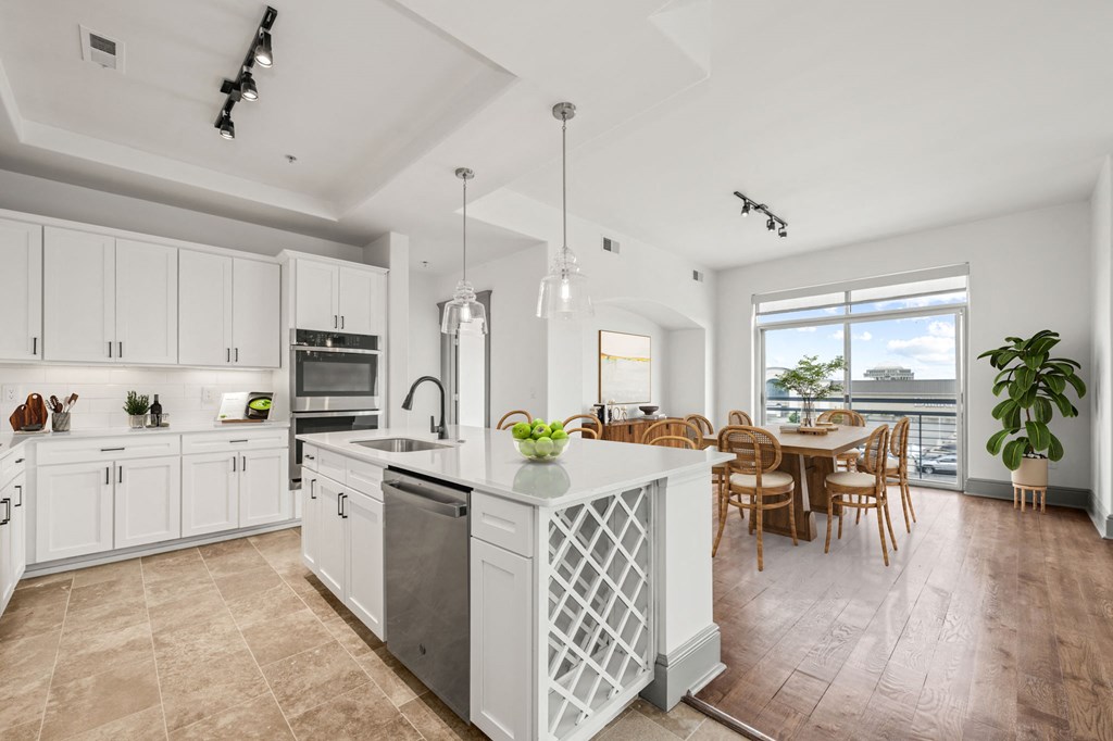 a large white kitchen with a large island and a dining room