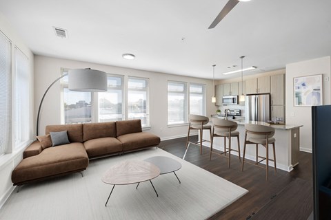A modern living room with a brown sofa and a grey floor lamp.