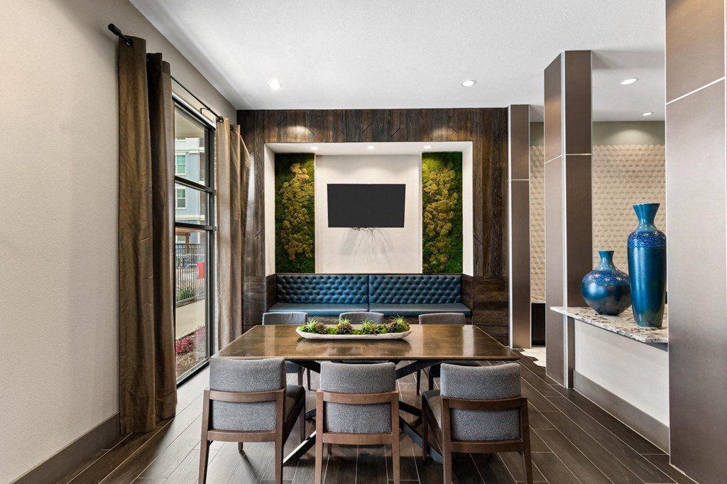 a dining room with a table and chairs and a tv on the wall
