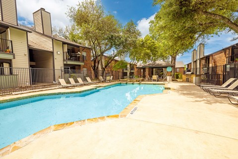A swimming pool surrounded by apartment buildings.