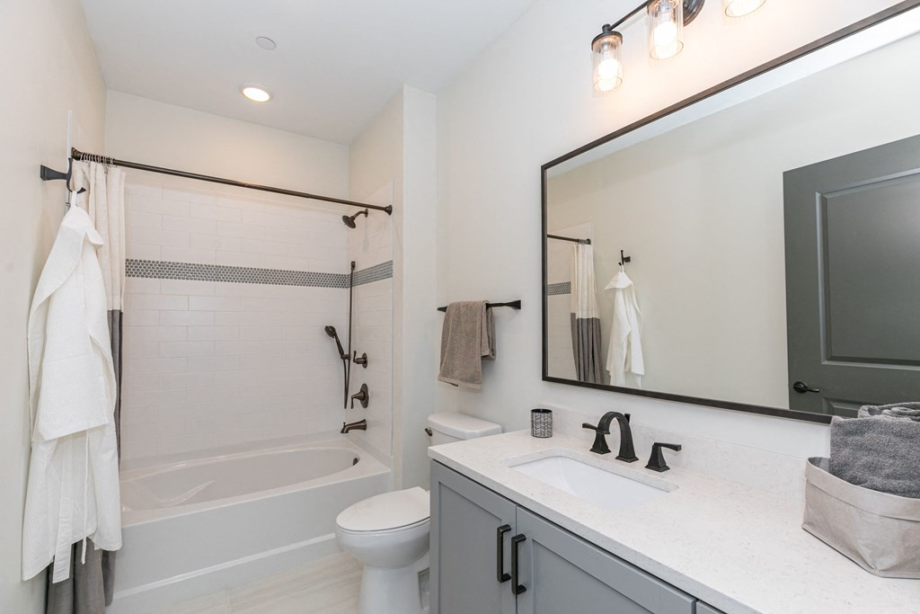 a bathroom with a sink toilet and shower and a mirror
