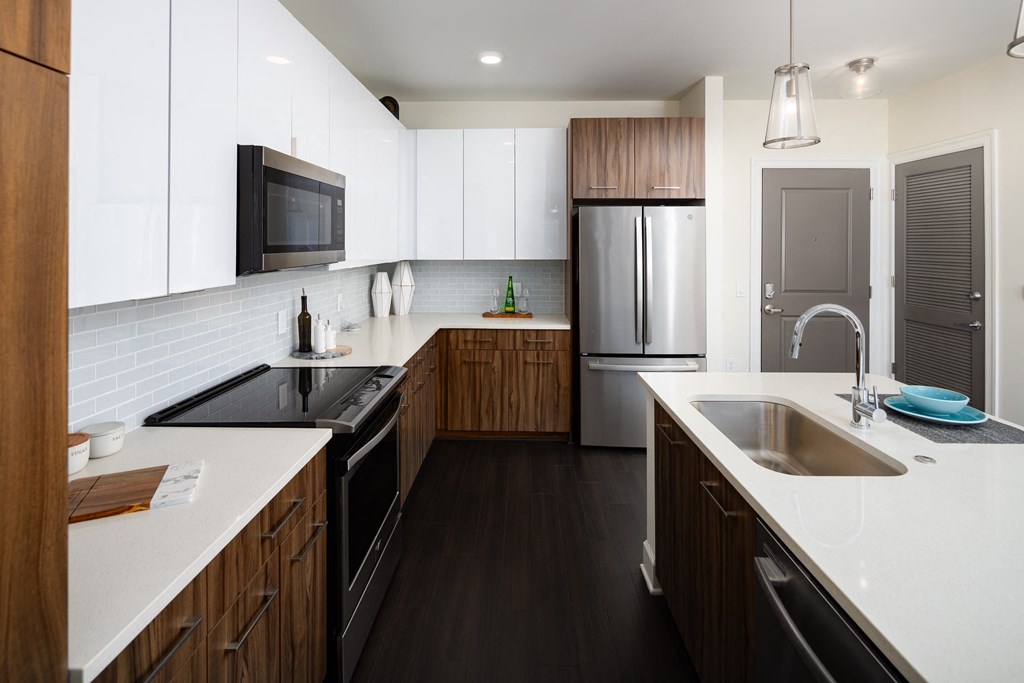 a large kitchen with white counter tops and wooden cabinets