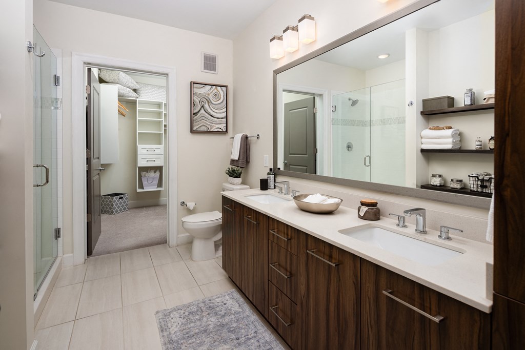 a bathroom with a large mirror and a sink and a toilet