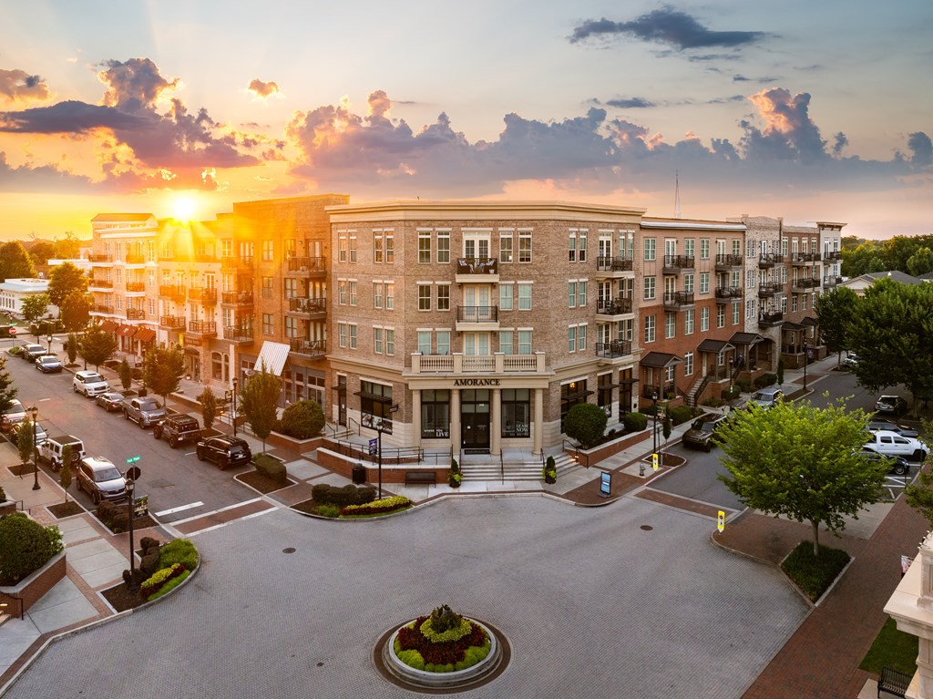 an aerial view of a large apartment building at sunset
