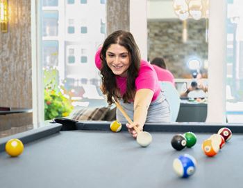 a woman playing pool at the clubhouse