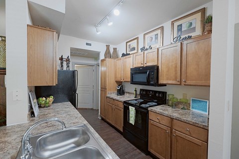 A kitchen with wooden cabinets and a black stove top oven.
