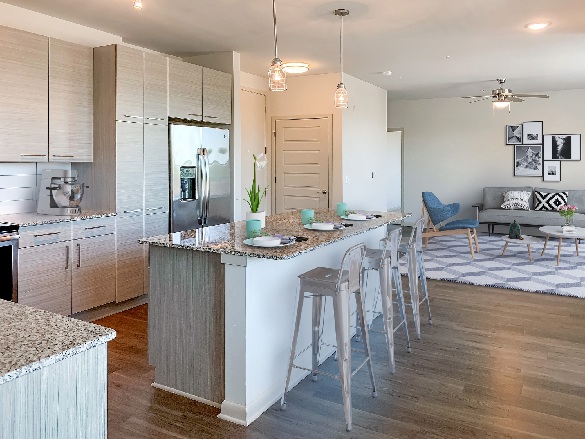 a kitchen with an island and bar stools in front of a living room