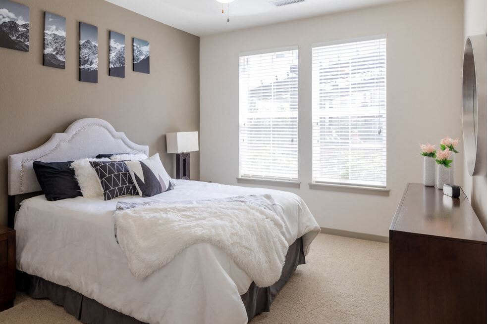 Centro Apartments model bedroom with 2 windows and white comforter