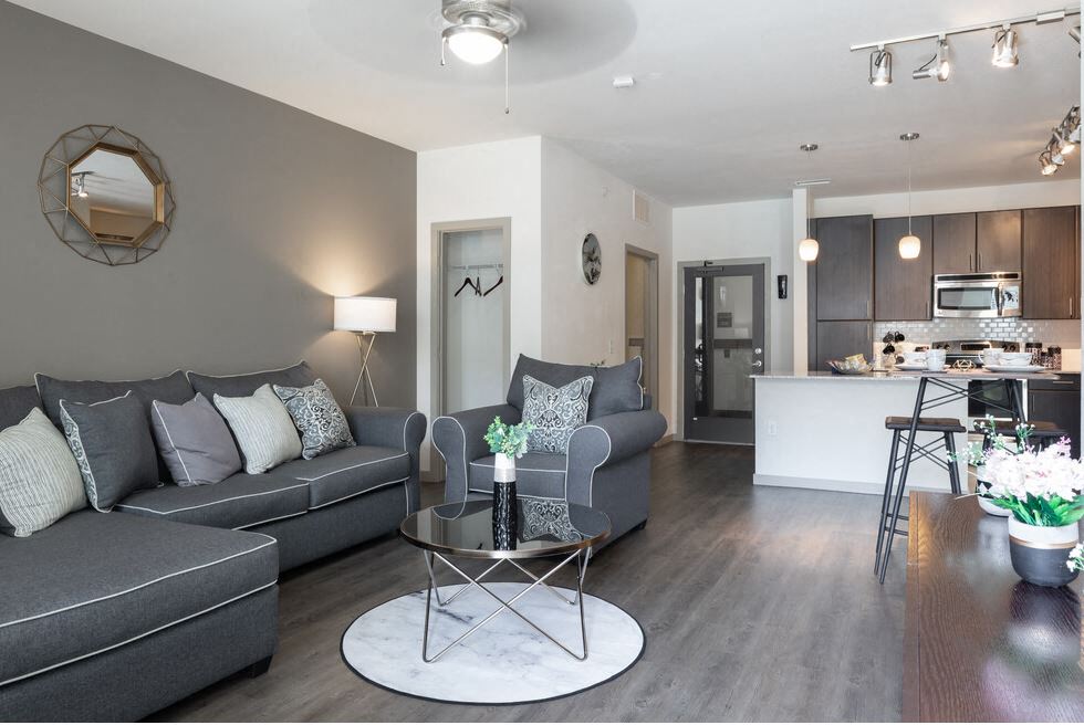 Centro apartments model living room with grey couch and white pillows