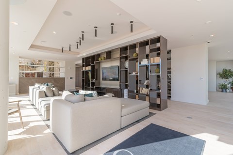 A modern living room with a white sofa and a wooden cabinet.