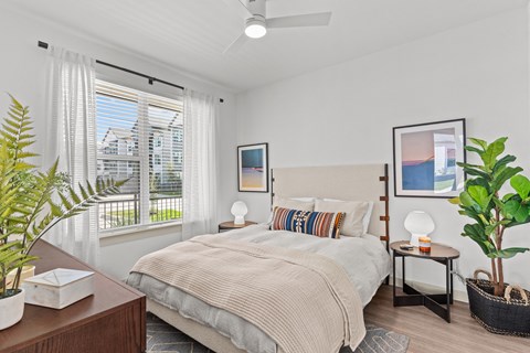 a bedroom with a bed and a large window