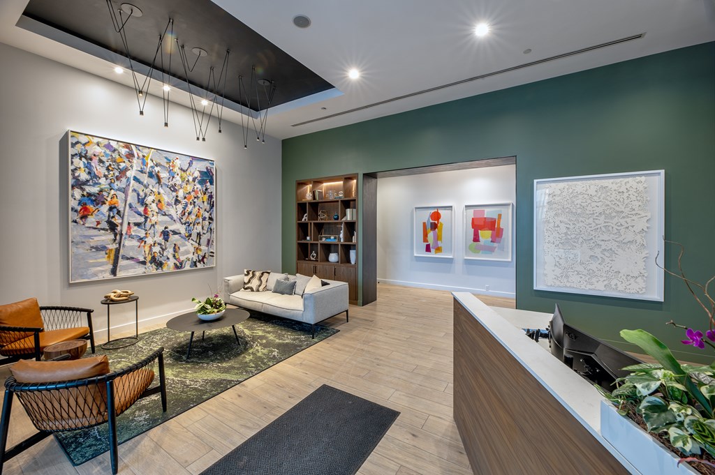 A reception area with a green wall and a large abstract painting.