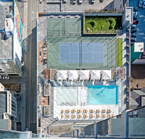 A building with a pool and a tennis court on the roof.
