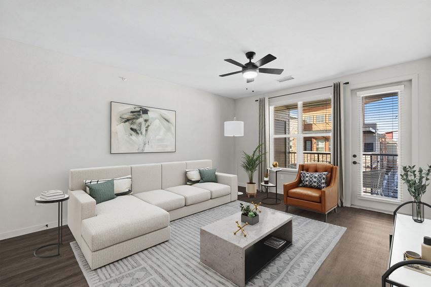 a living room with a large window and a ceiling fan