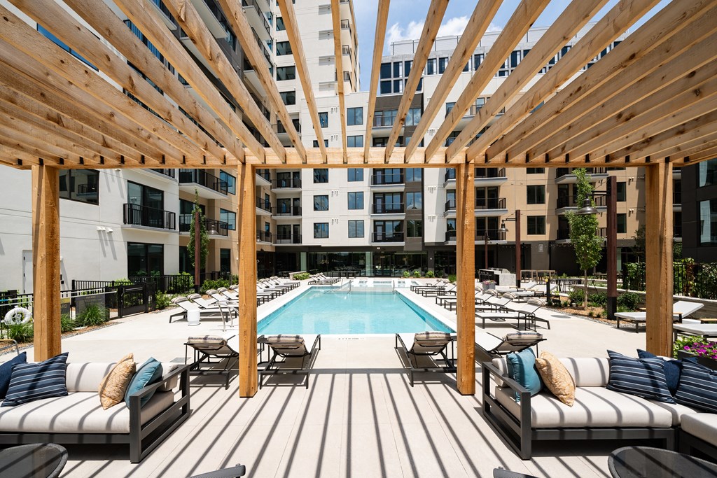a pool area with lounge chairs and a resort style pool