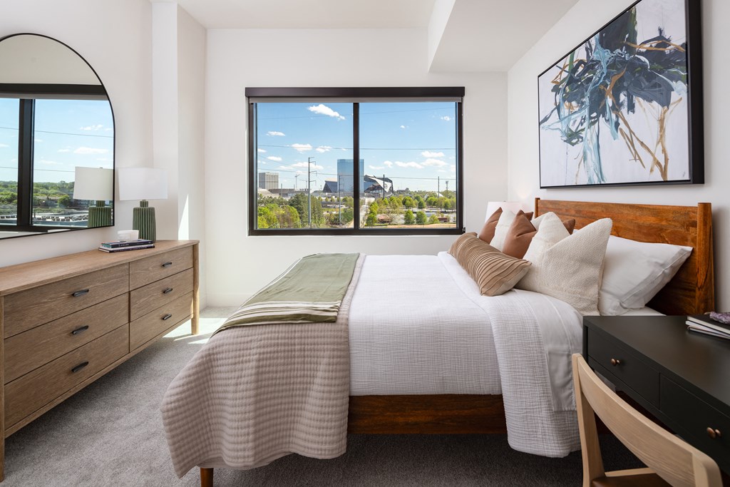 a bedroom with a bed and a view of the city