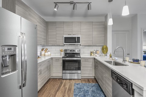 a kitchen with stainless steel appliances and white counter tops