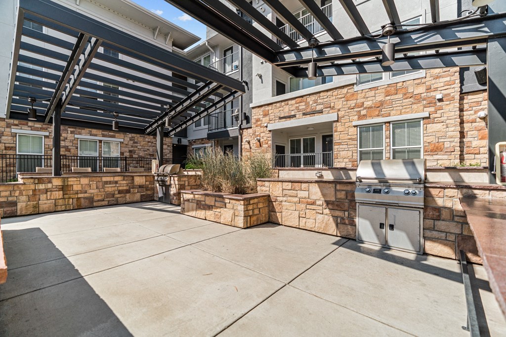 a patio with a barbecue grill and a pergola