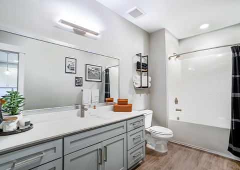a bathroom with a large mirror and a toilet and a shower