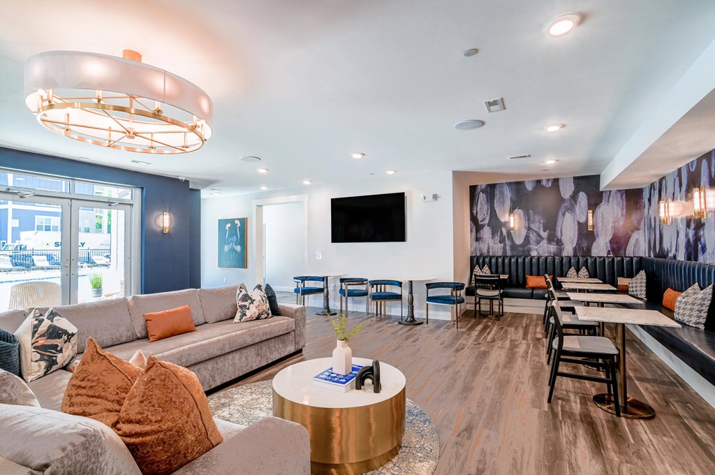 a living room with couches tables and chairs and a wall mural