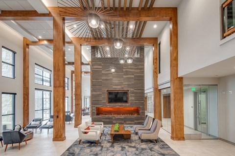 a living room with a stone fireplace and wooden pillars