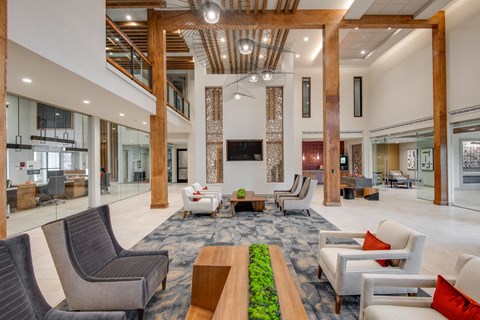 A large, modern living room with a long wooden table and chairs.