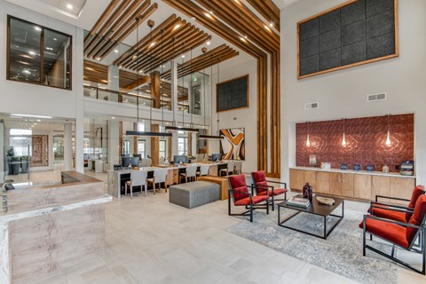 a large lobby with chairs and tables and a large mirror