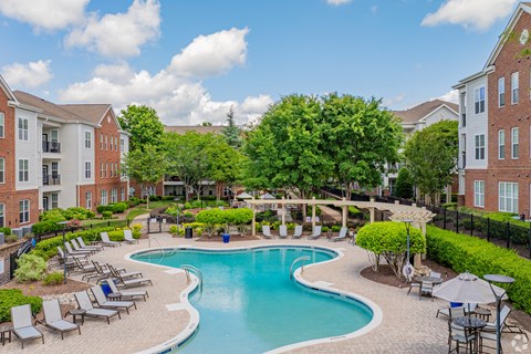 A large swimming pool surrounded by lounge chairs and umbrellas.